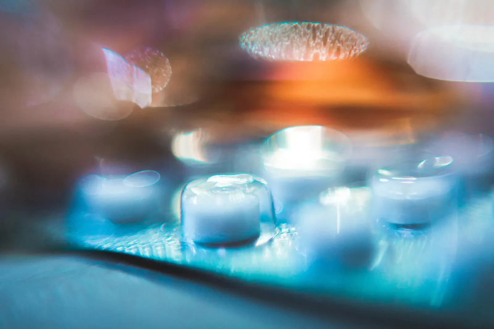 Unscharfe Nahaufnahme von Kapseln in einem Blister unter blauem Licht, Symbolbild für Antibiotikaresistenz und multiresistente Keime