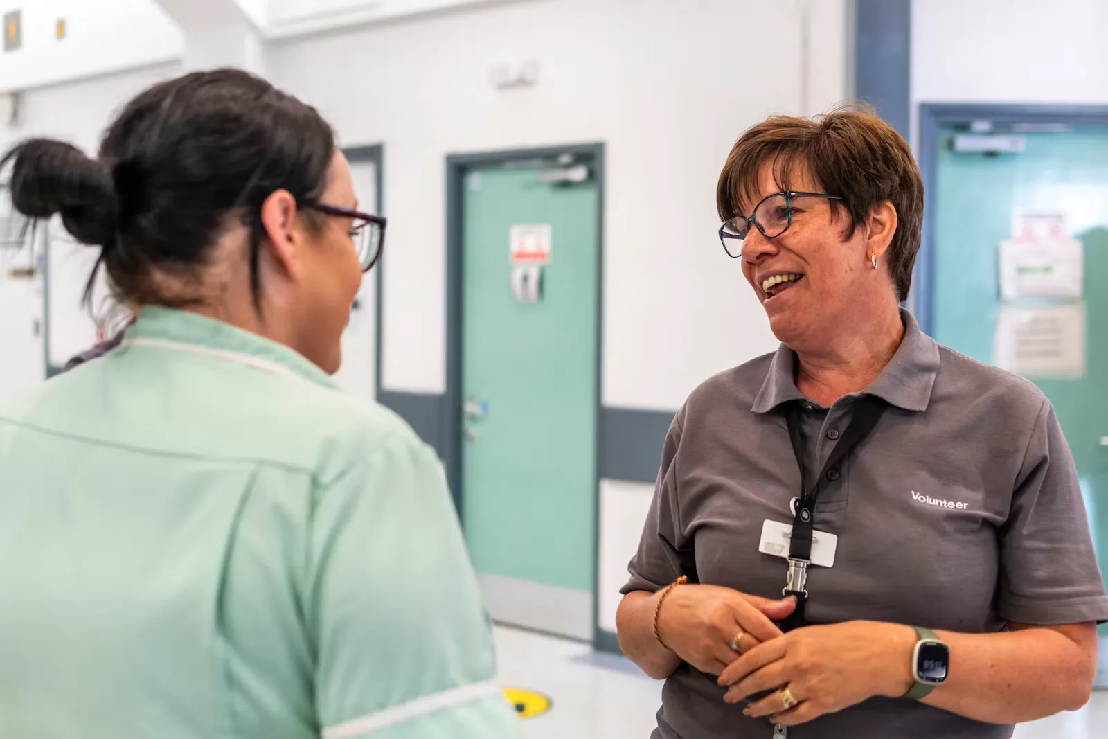 Intern talking with a staff member in a hospital hallway, illustrating direct communication during a clinical internship abroad