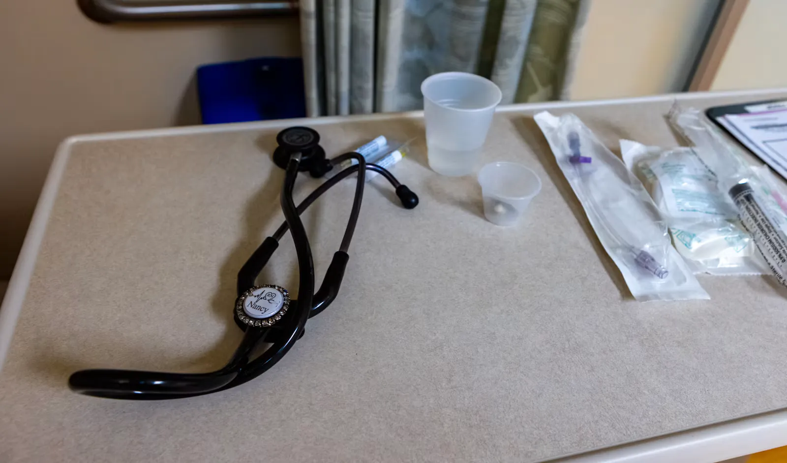 Schwarzes Stethoskop, Spritzen und Becher liegen auf einem Beistelltisch im Behandlungszimmer, Symbolbild für die Krankenhausfamulatur im Ausland