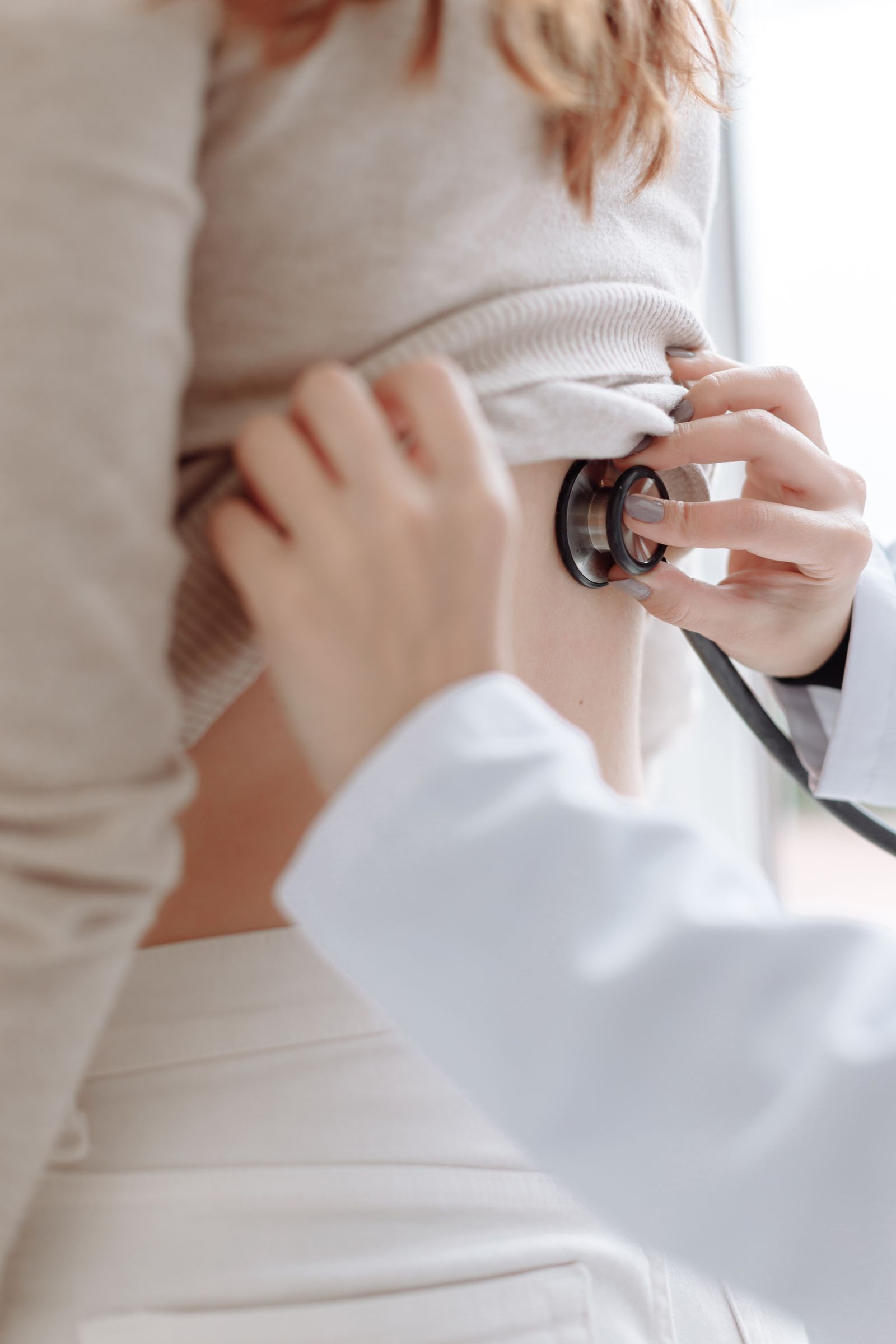 Clinician examining a patient's back with a stethoscope, representing the hands-on ward work of a practical year abroad placement