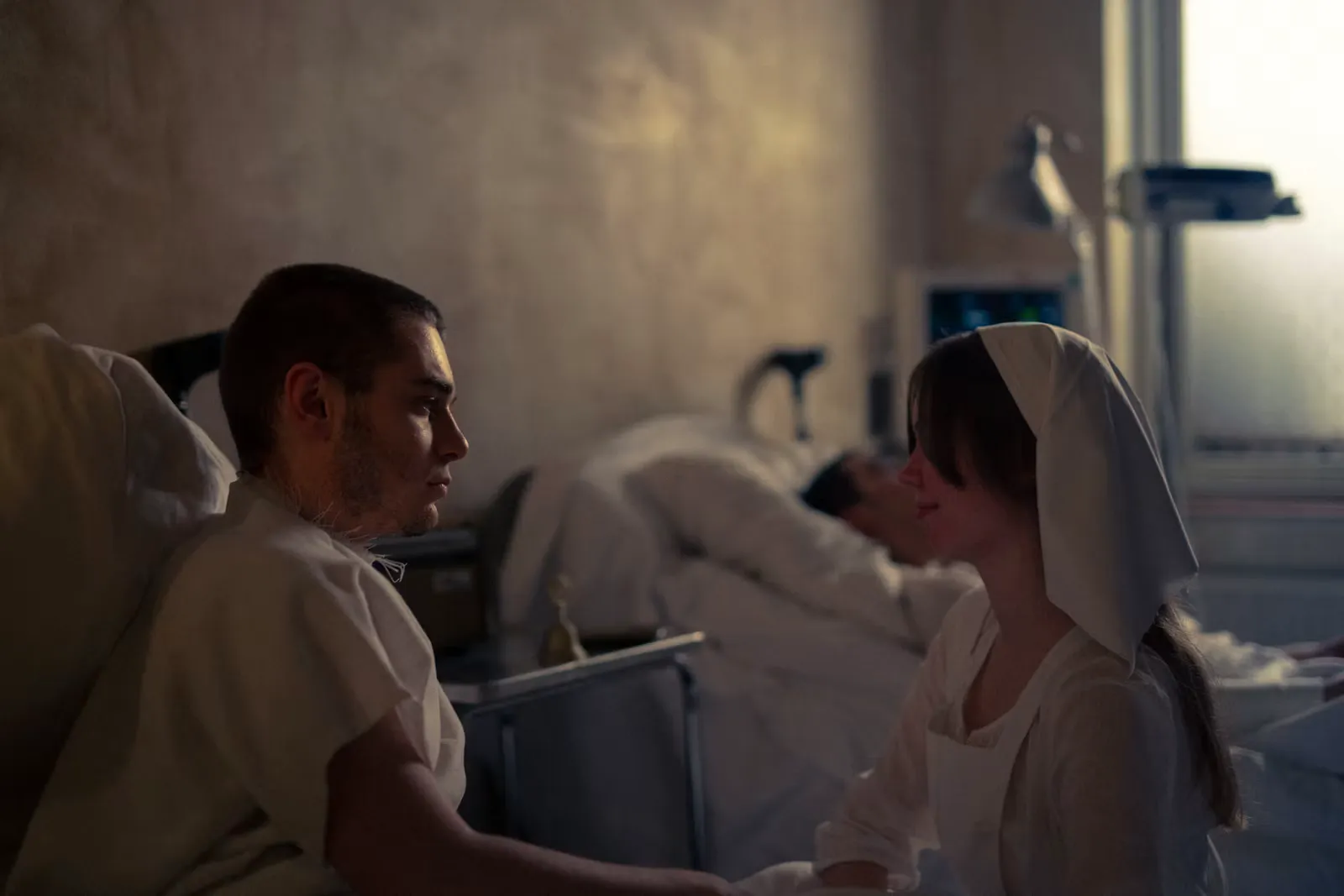A visitor sitting beside a patient in a hospital bed