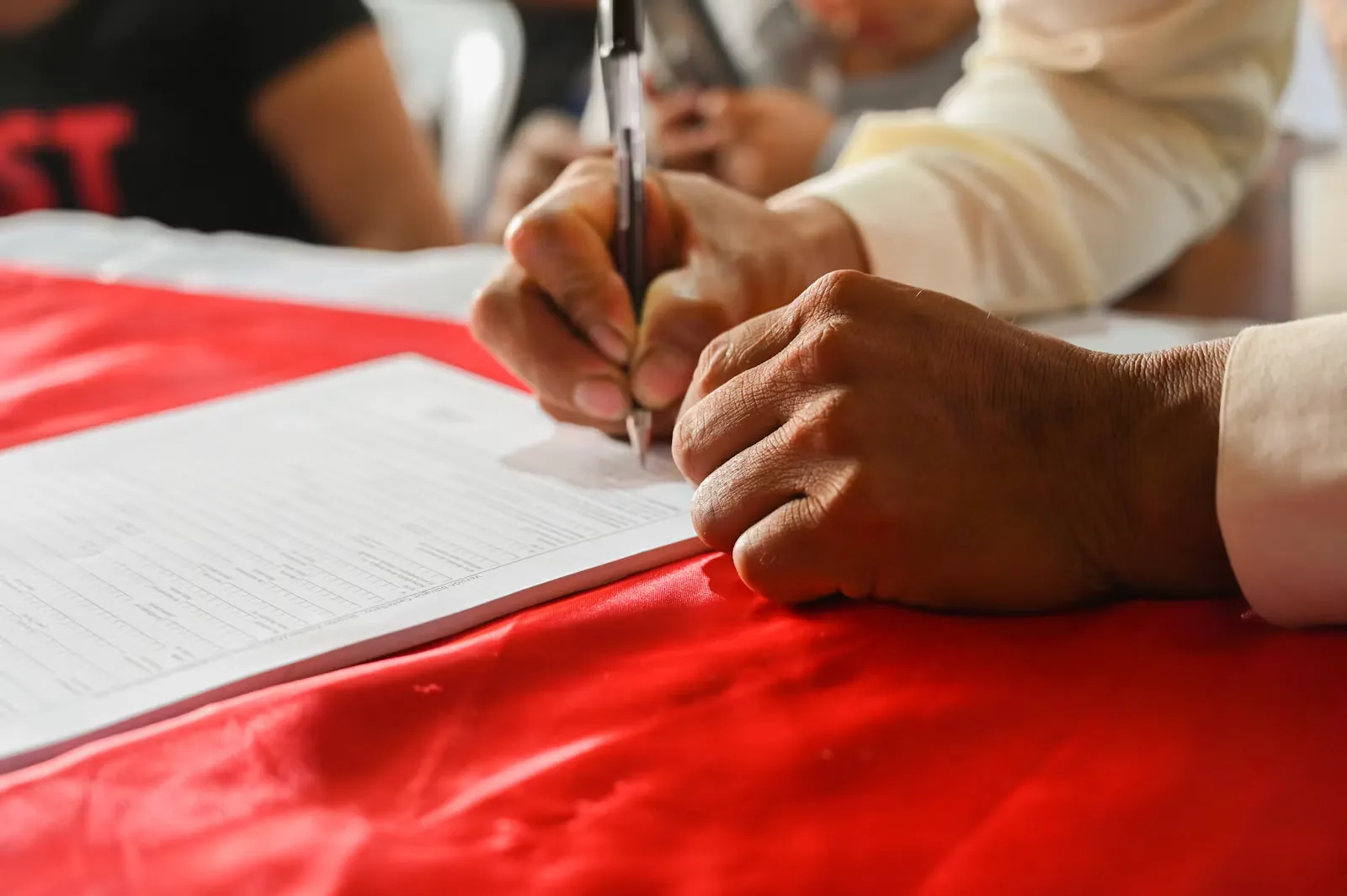 A person writing on a printed form at a desk, filling in placement paperwork