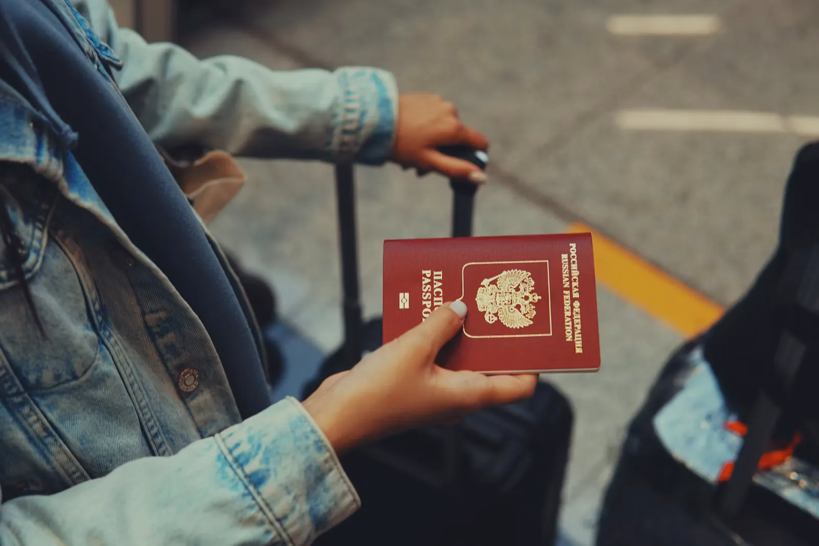 Person hält einen roten Reisepass in der Hand