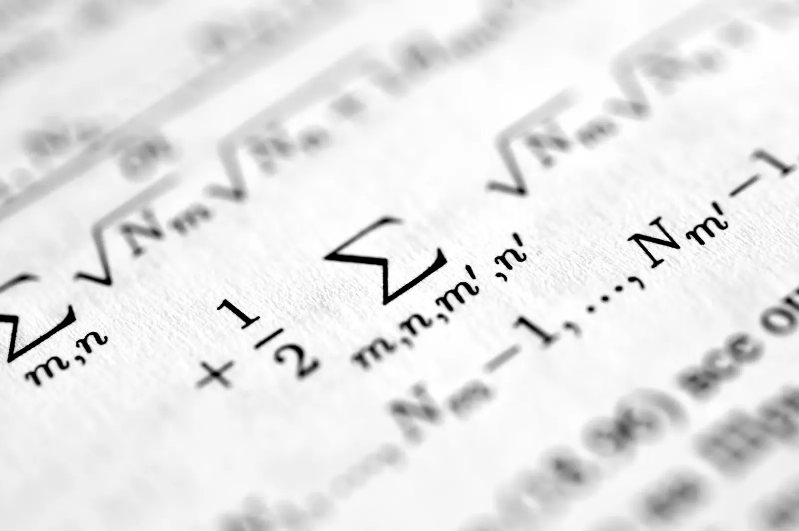 Nahaufnahme mathematischer Formeln mit Summenzeichen und Wurzeln auf bedrucktem Papier, Sinnbild für die quantitativen Aufgaben im TMSnat 2027