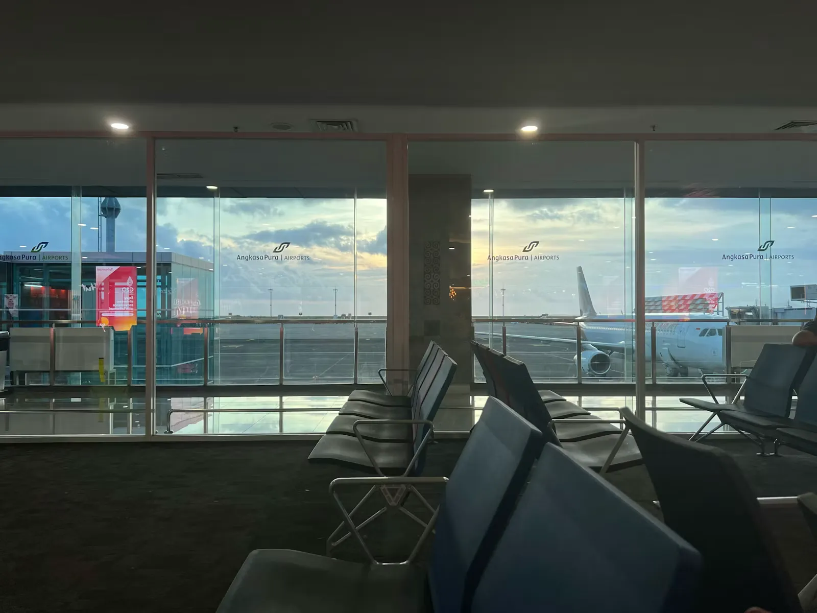 Helle Abflughalle mit großer Fensterfront und Blick auf das Vorfeld, Sinnbild für die Einreise nach Indonesien mit dem Visum Bali