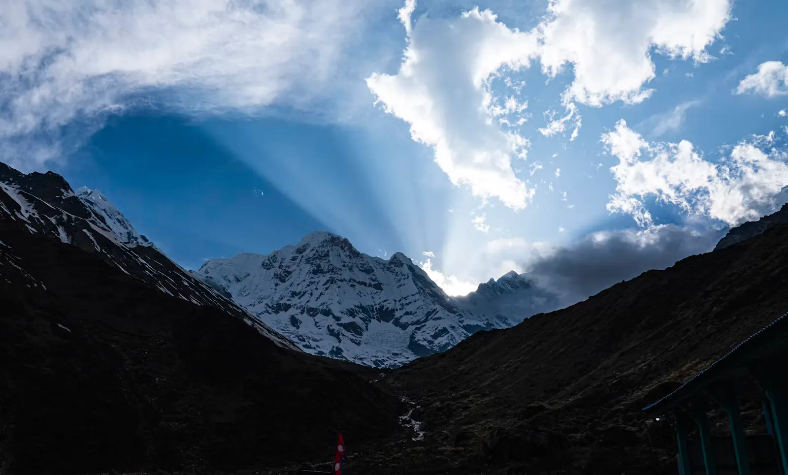 Sonnenlicht bricht durch Wolken über schneebedeckten Achttausendern der Annapurna-Region – Kulisse für eine Famulatur in Nepal am Fuss des Himalaya