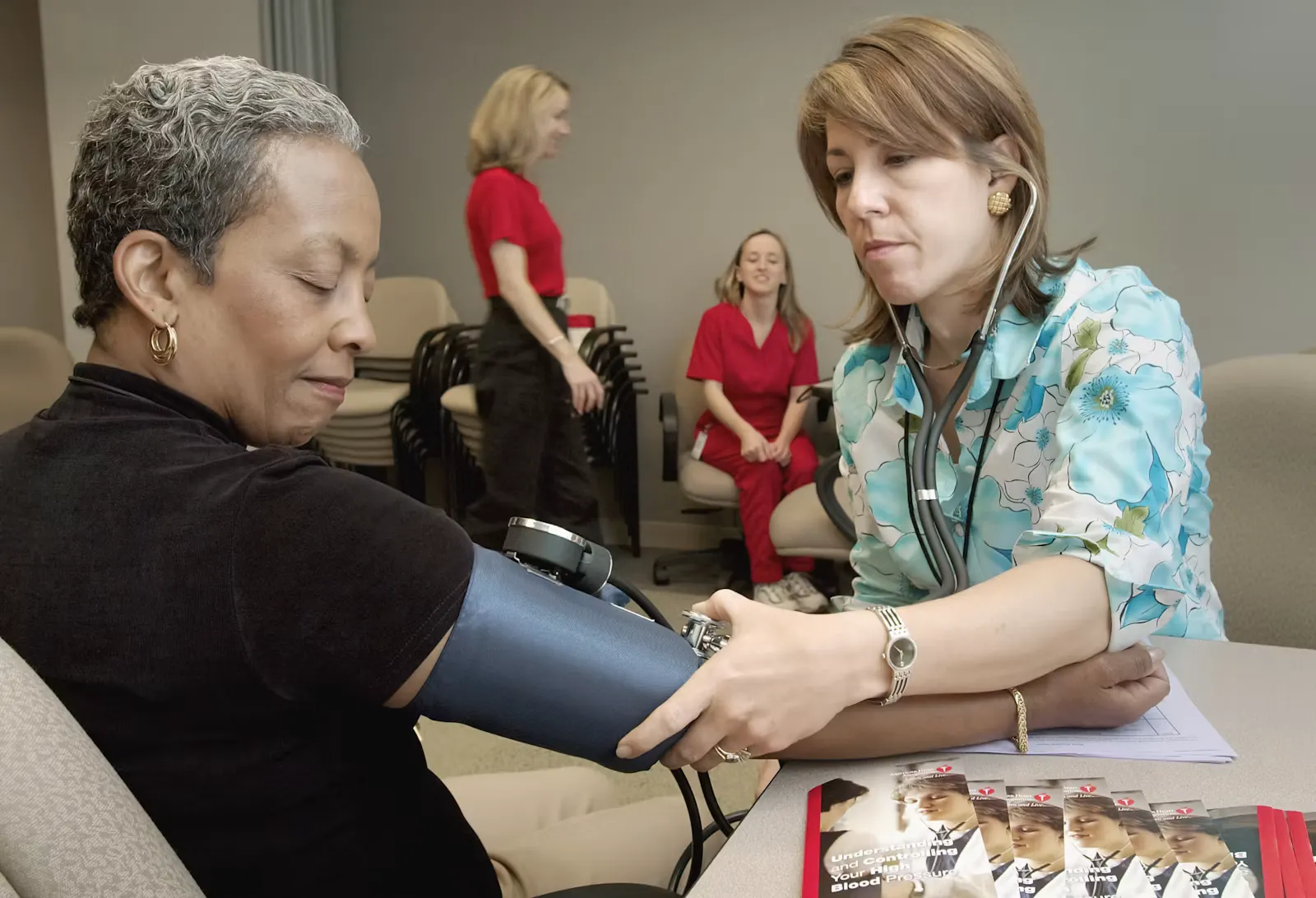 Doctor in a clinic checking a patient's blood pressure with a stethoscope and cuff, everyday work that statutory pay rules cover