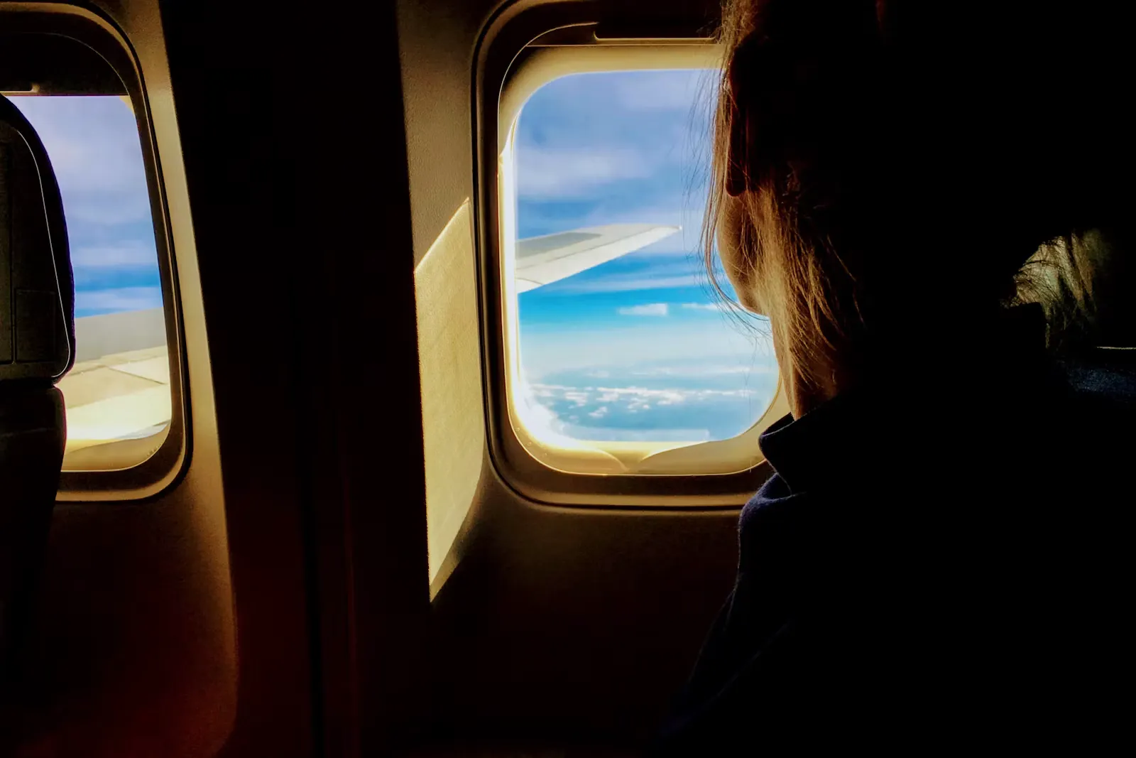 Blick aus dem Flugzeugfenster auf einen hellen Himmel während des Fluges zum Auslandspraktikum