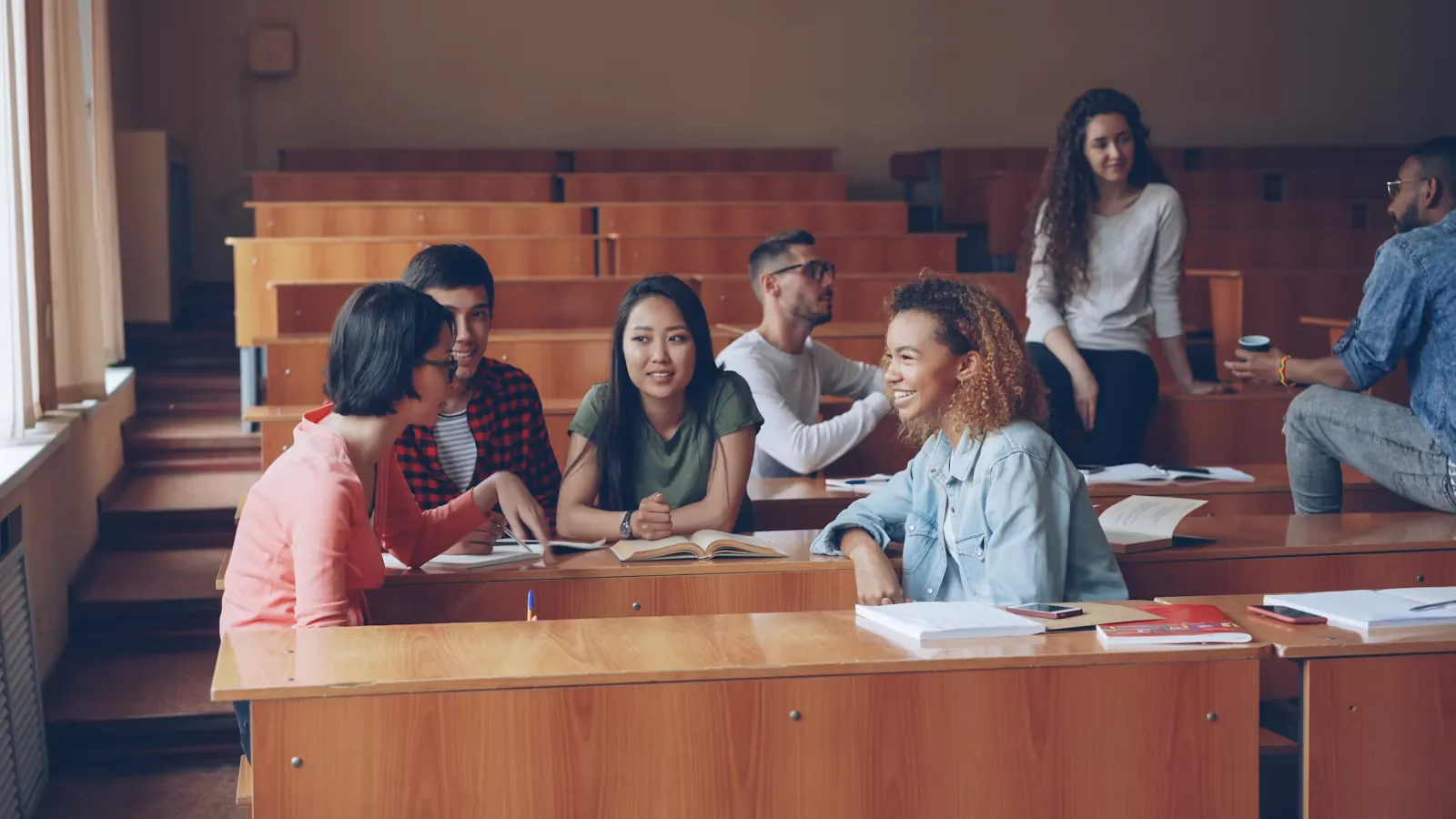 Studierende im Gespräch und beim Lernen im Hörsaal