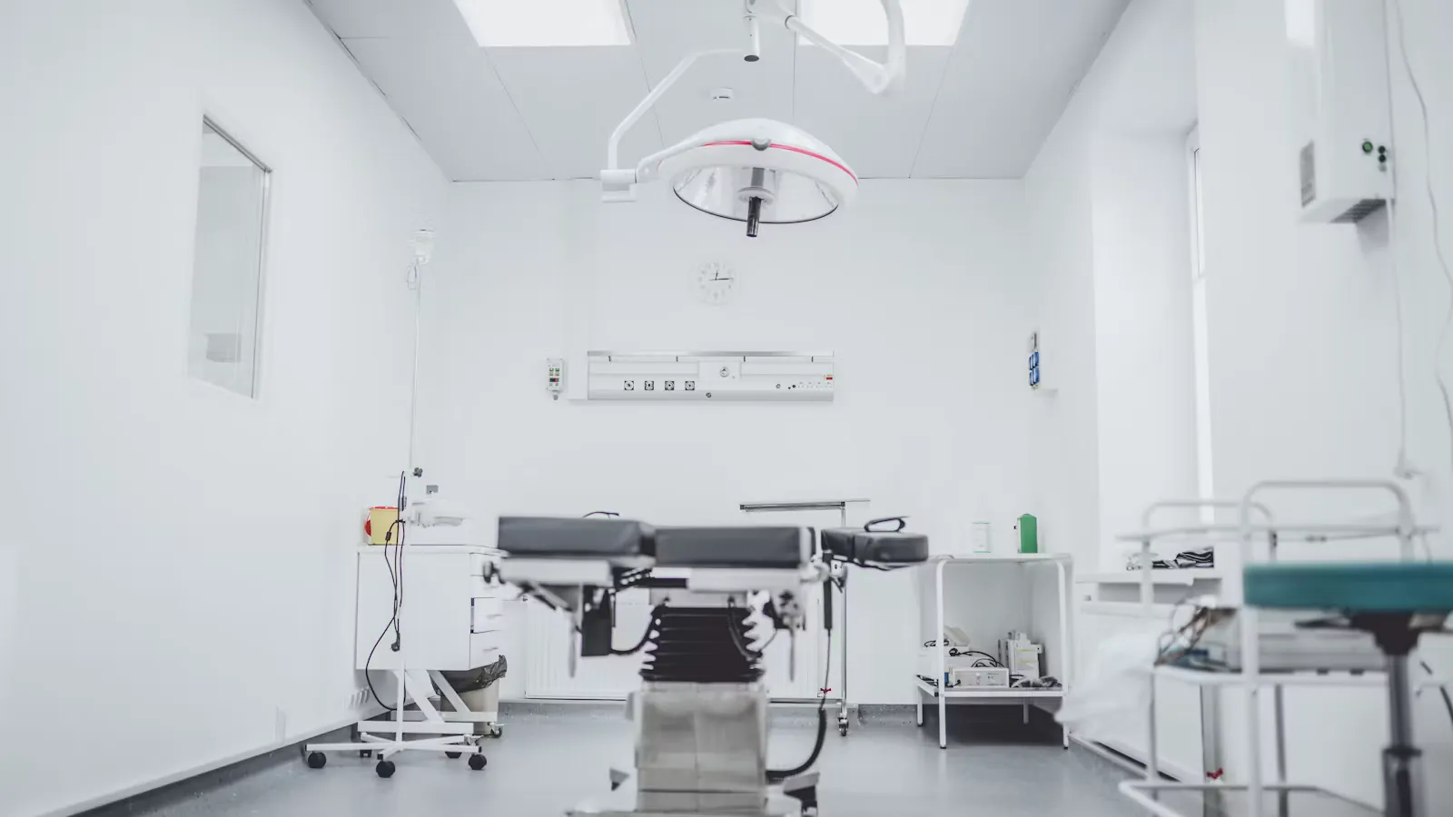 Empty modern operating theatre with overhead surgical lamp, the kind of hospital setting where statutory doctor pay rules apply