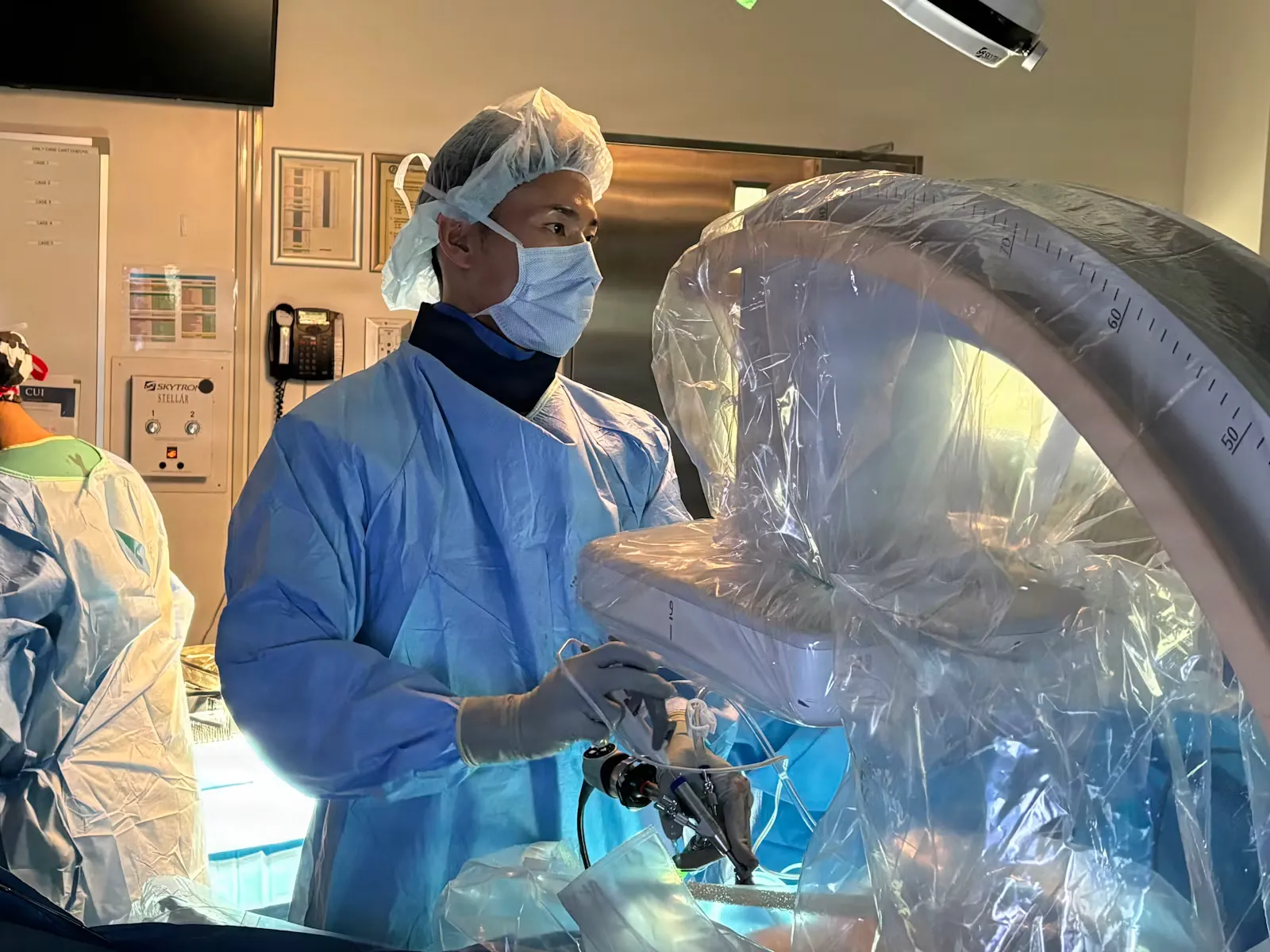 Chirurg mit Maske steuert ein robotisches Operationssystem