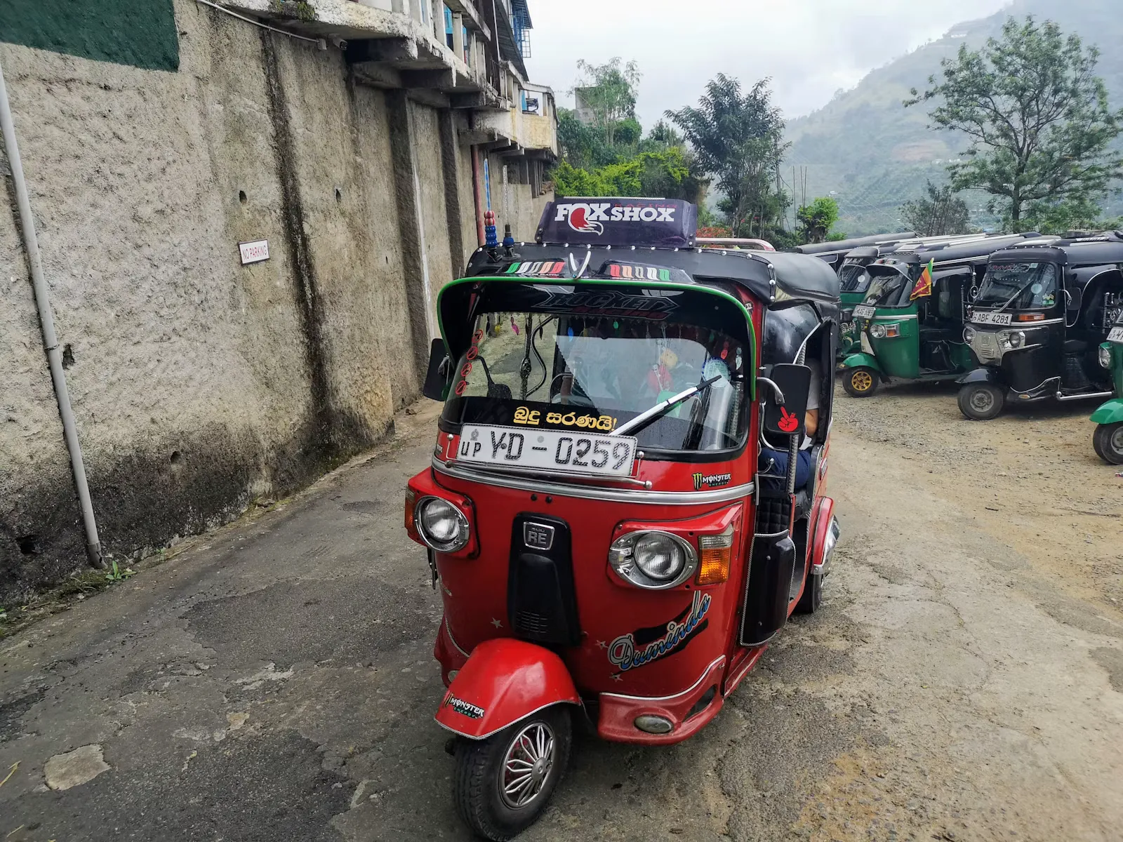 Rotes Tuk-Tuk auf einer Straße in Badulla, Sri Lanka, wie Praktikant:innen es auf dem Weg zur Klinik nutzen