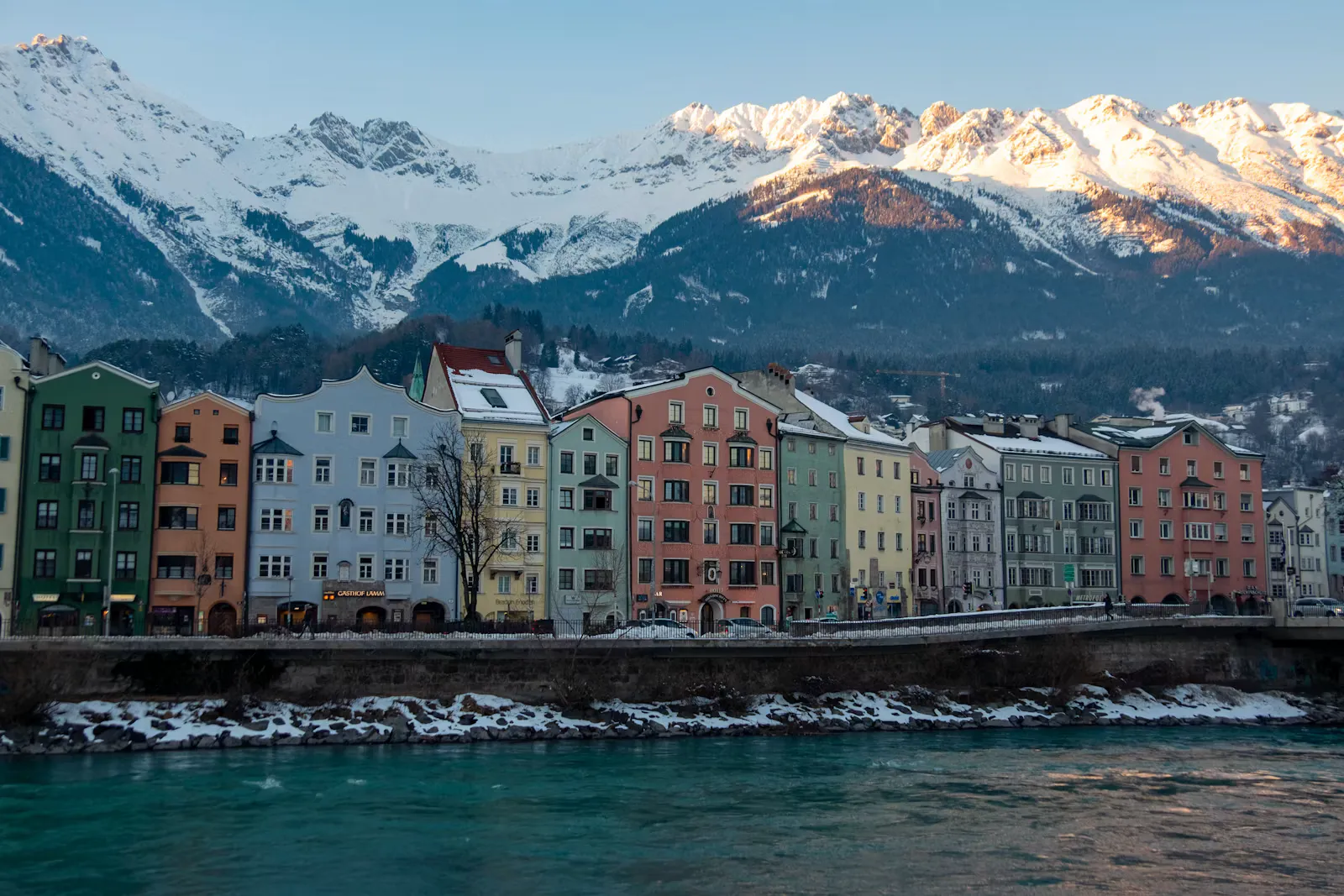 Häuserzeile am Inn in Innsbruck im Winter, verschneite Berge im Hintergrund, Symbolbild für die KPJ-Planung an der MedUni Innsbruck