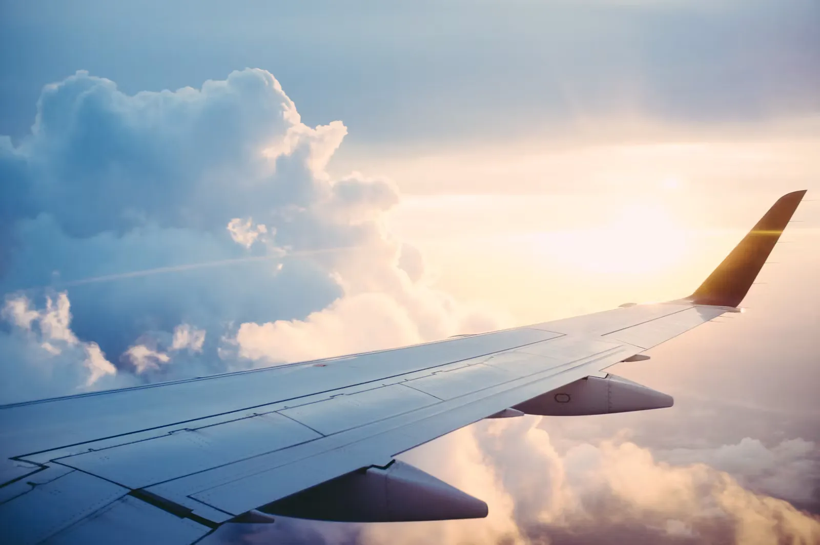 Tragfläche eines Flugzeugs über den Wolken – Symbolbild für die Anreise zum klinischen Praktikum auf Bali oder Sansibar