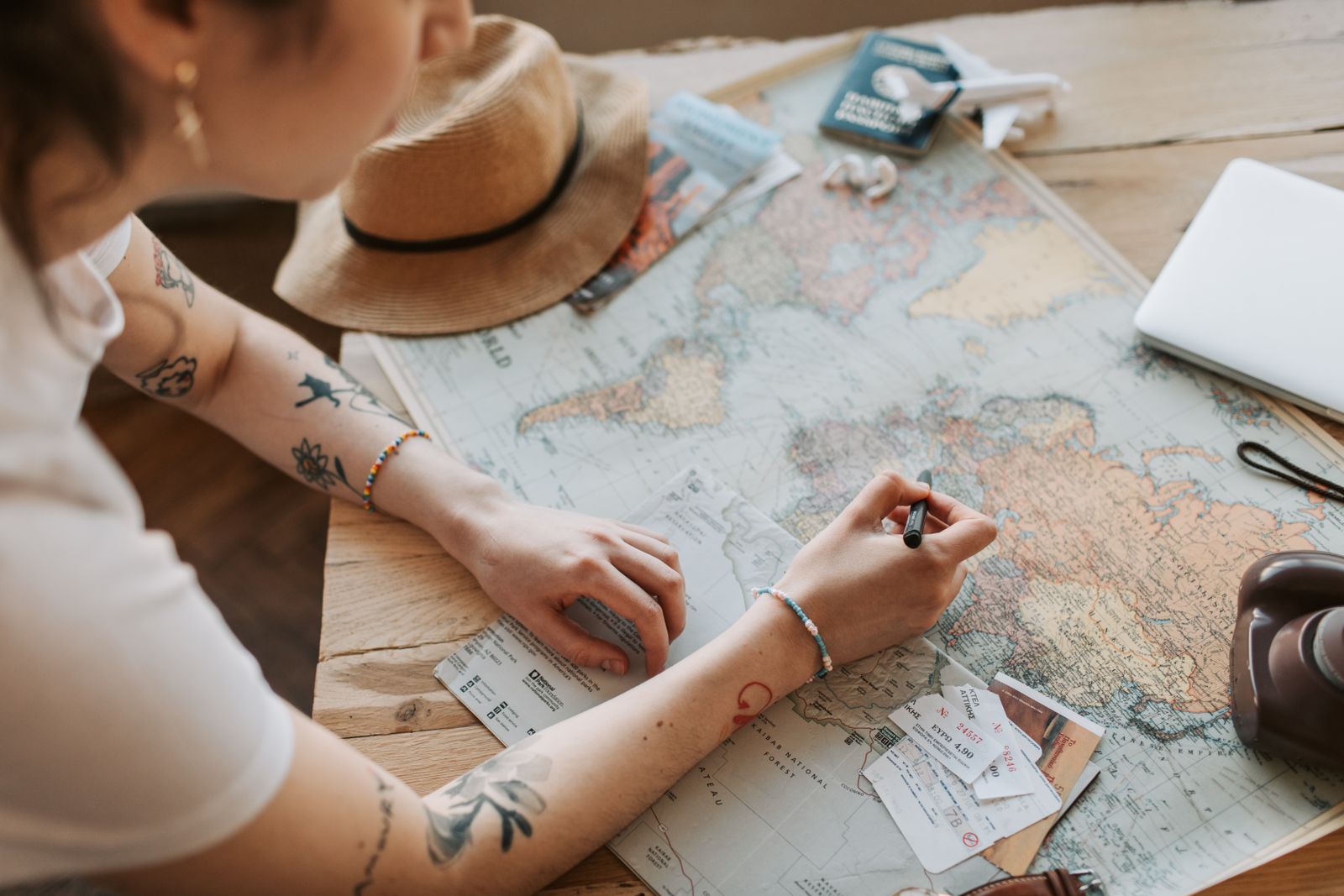 Passport and a world map laid out on a table with a pen, representing the travel-document preparation for a clinical clerkship on a cruise ship