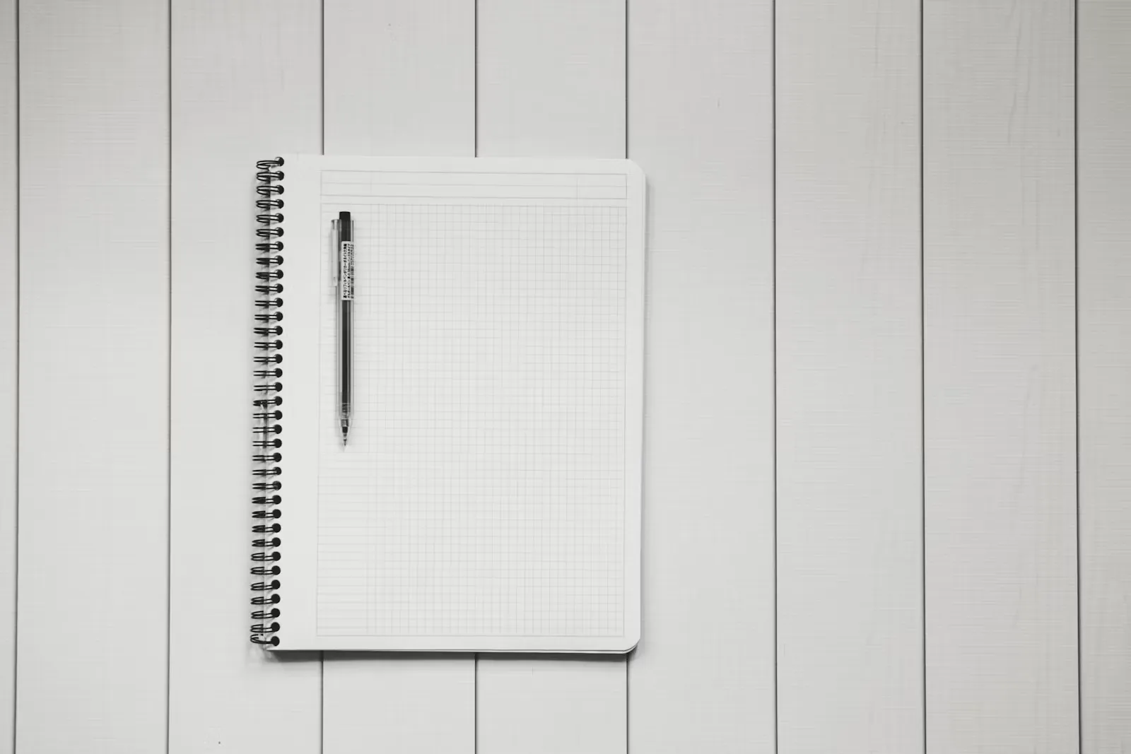 Handschriftliche Notizen und eine Checkliste in einem karierten Notizbuch auf einem Schreibtisch