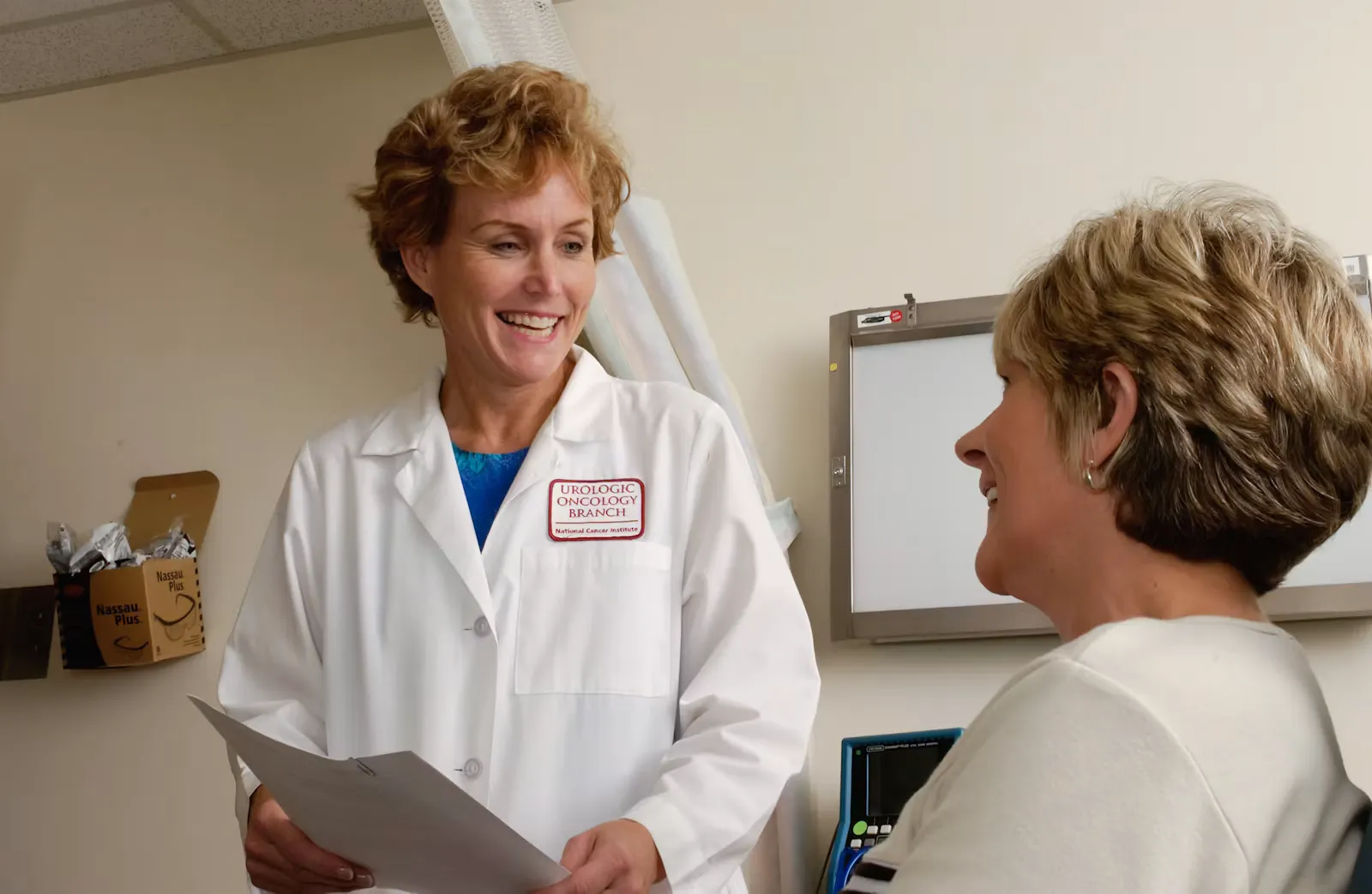 Doctor in a white coat talking with a patient in a clinic, illustrating the language and registration requirements behind an EU Blue Card for doctors