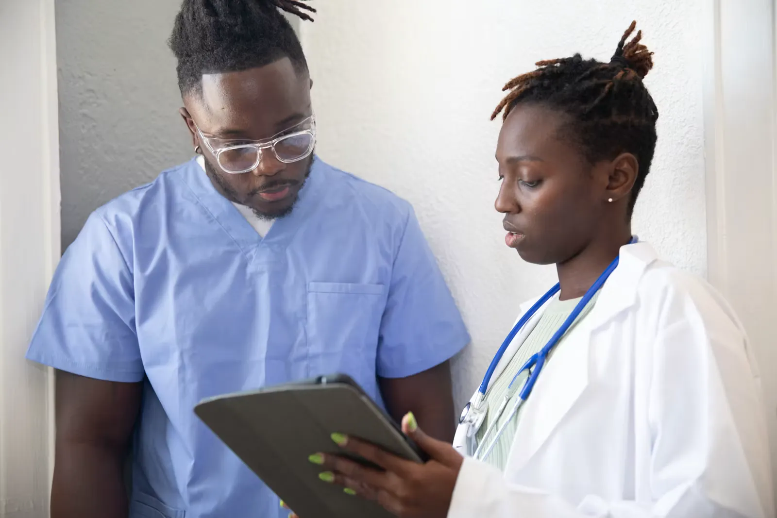 Ärztin zeigt einem Patienten etwas auf dem Tablet