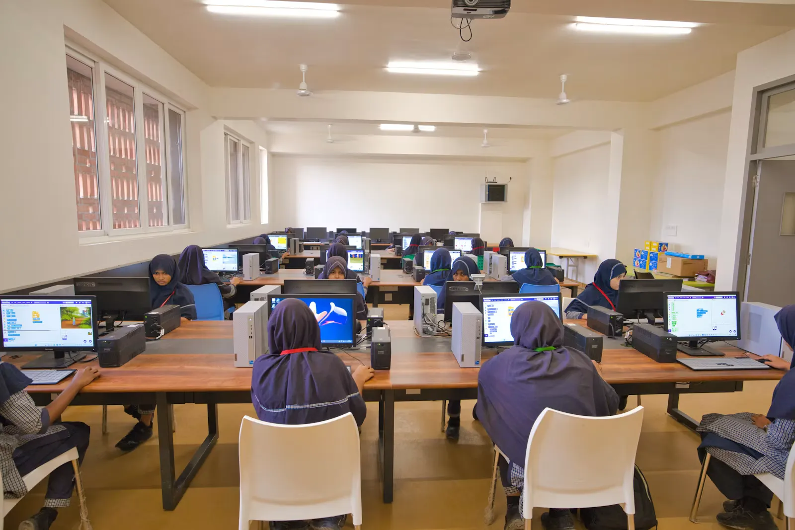 Students working at computers in a bright school computer lab, the kind of setting used for computer-delivered medical licensing exams