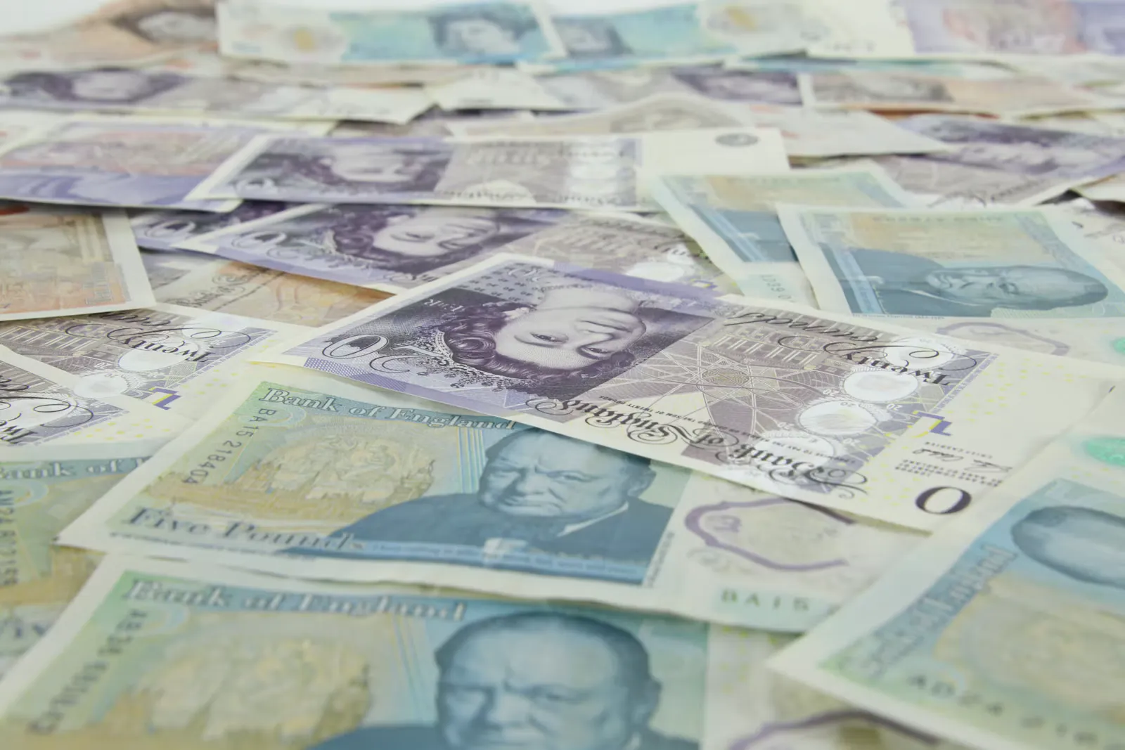 British twenty pound and five pound banknotes scattered across a table