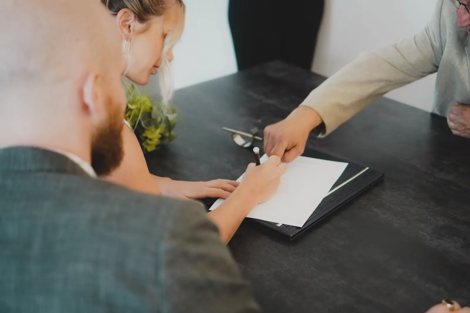 Nahaufnahme einer Hand, die mit einem Stift ein Dokument unterschreibt