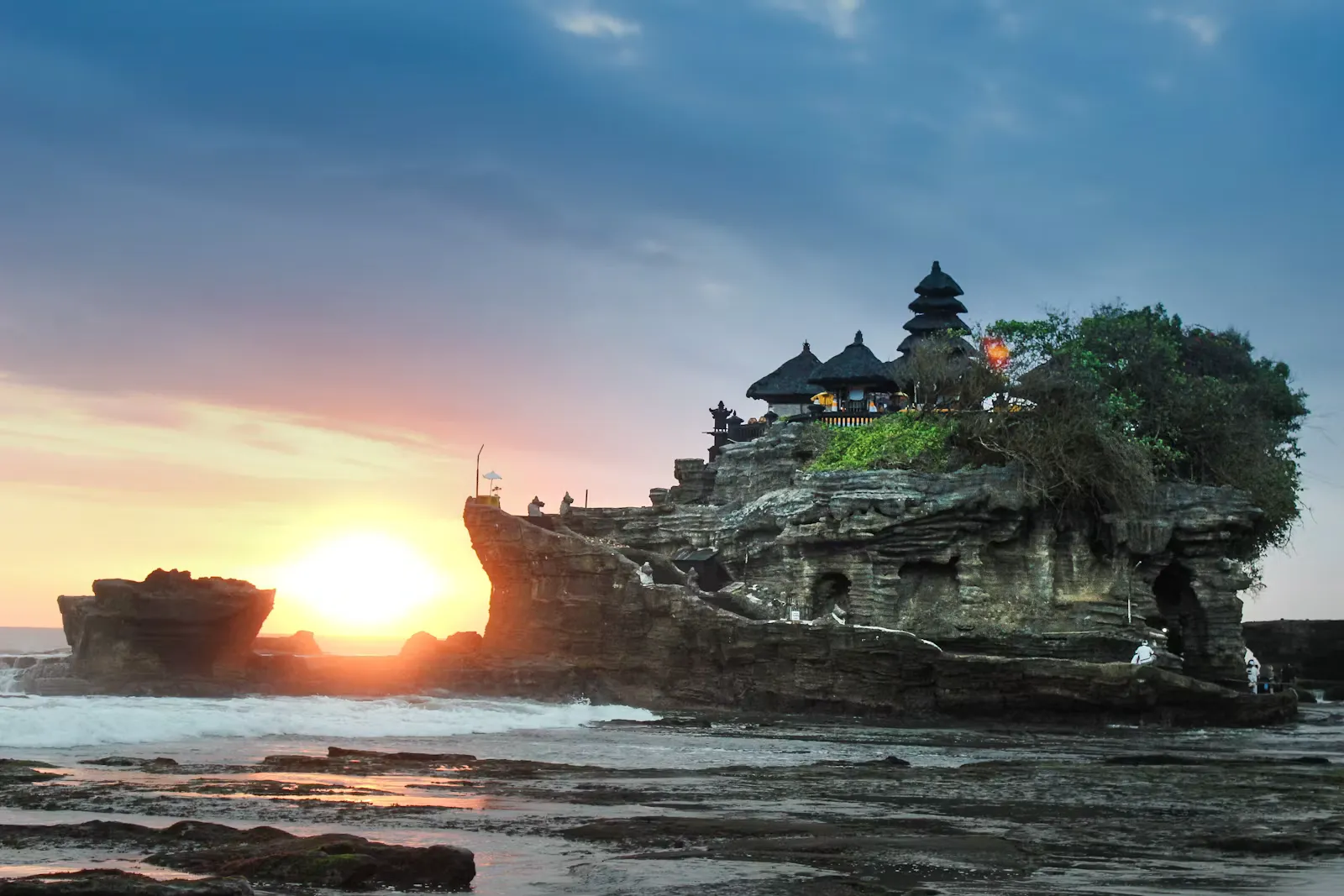 Der Tempel Tanah Lot auf einem Felsen im Meer vor Bali im Sonnenuntergang, Symbolbild für ein Praktikum auf Bali