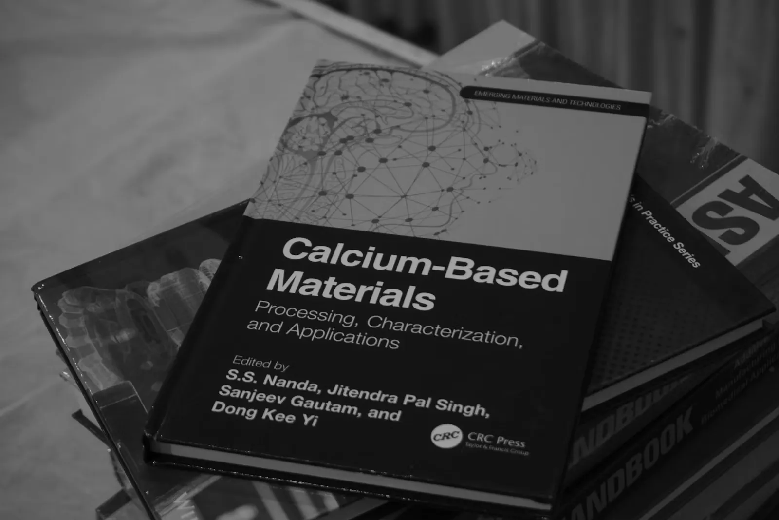 A stack of hardback books resting on top of each other, standing in for the NCERT Biology textbooks a NEET Biology MCQ is written from