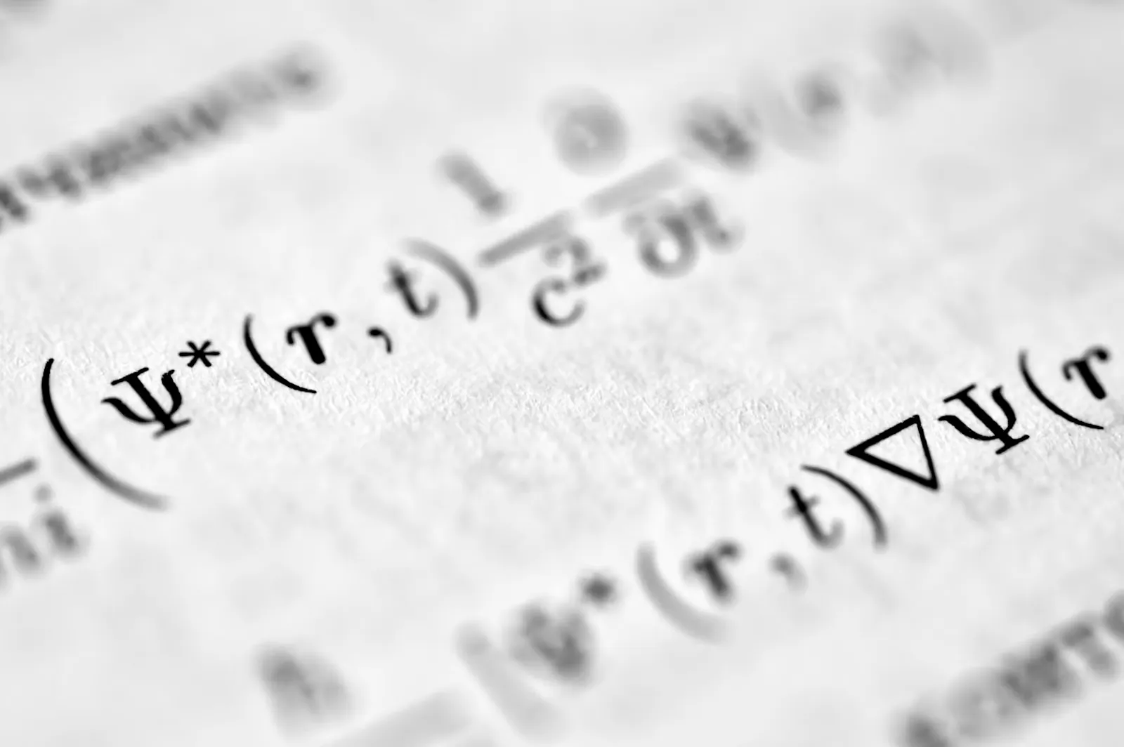 A close-up of printed physics equations on a page, the kind of symbol-heavy text NEET Physics questions are written from