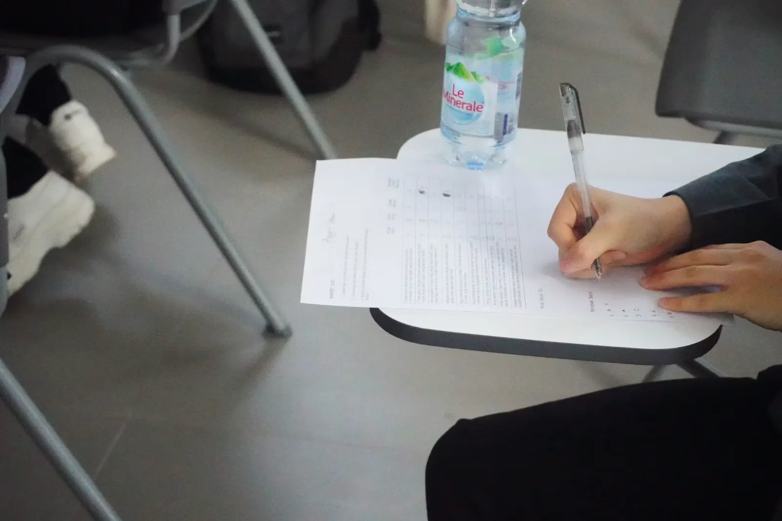 Person schreibt auf ein Blatt Papier