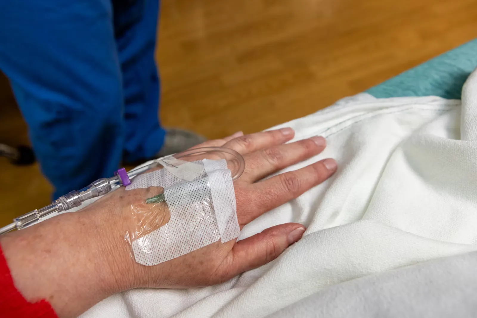 A nursing student inserting an IV line into a patient's hand, similar to the hands-on clinical tasks during a nursing internship in Bali