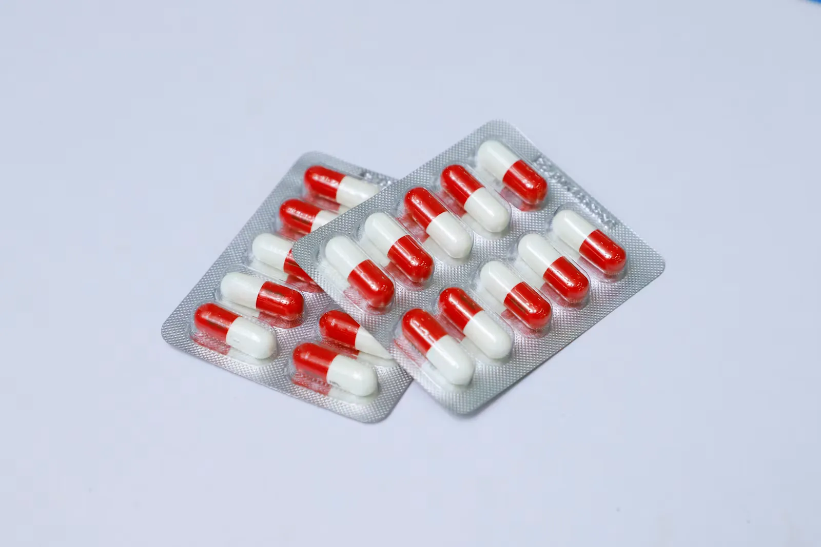 Blisterpackung mit weißen und roten Tabletten auf hellem Untergrund, Sinnbild für die verschreibungspflichtige Chemoprophylaxe