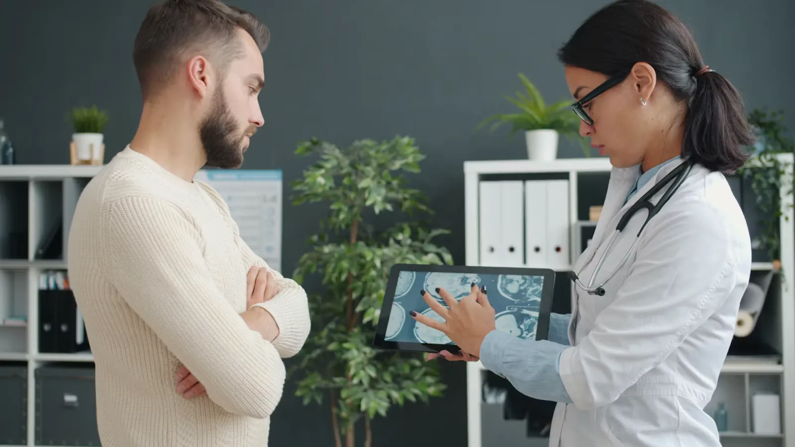 A doctor showing a patient a medical scan on a tablet