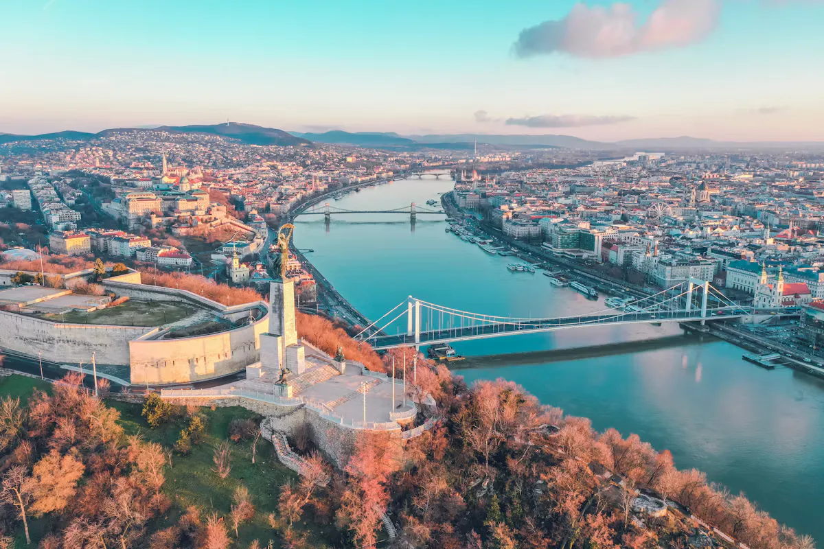 Aerial view of Budapest at sunrise with the Liberty Statue on Gellert Hill, the white Elisabeth Bridge over the Danube and the city stretching to the hills