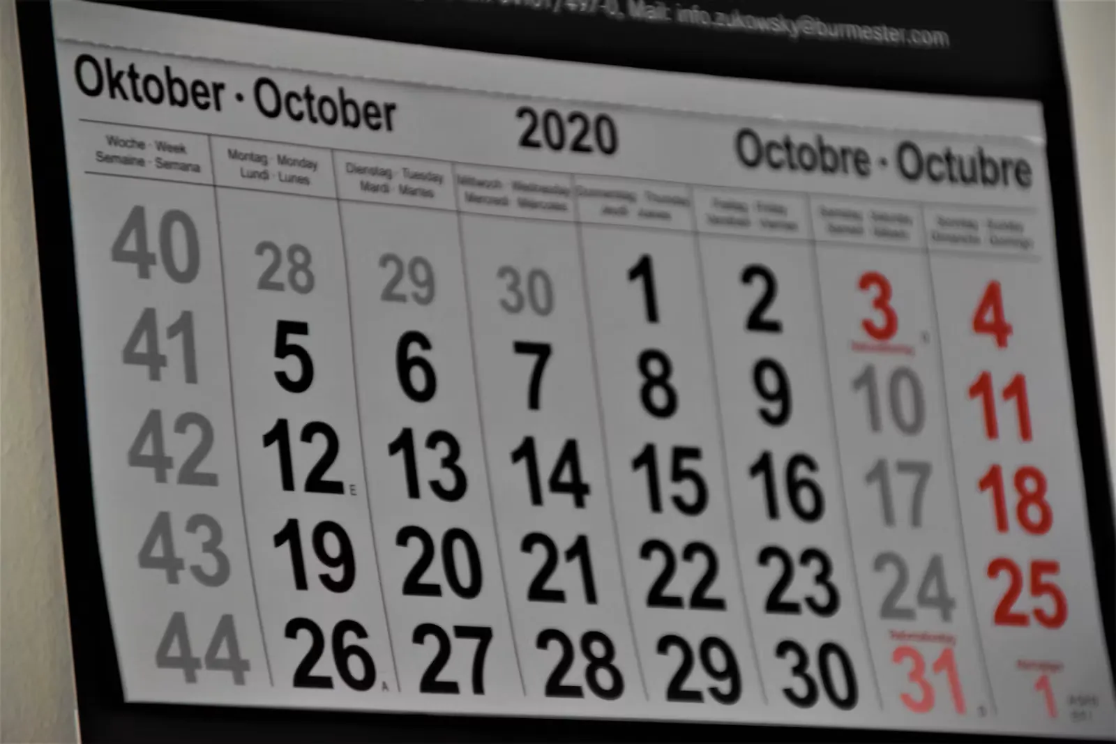 Wandkalender mit dem Monatsblatt Oktober, großen schwarzen Tageszahlen und rot markierten Wochenenden