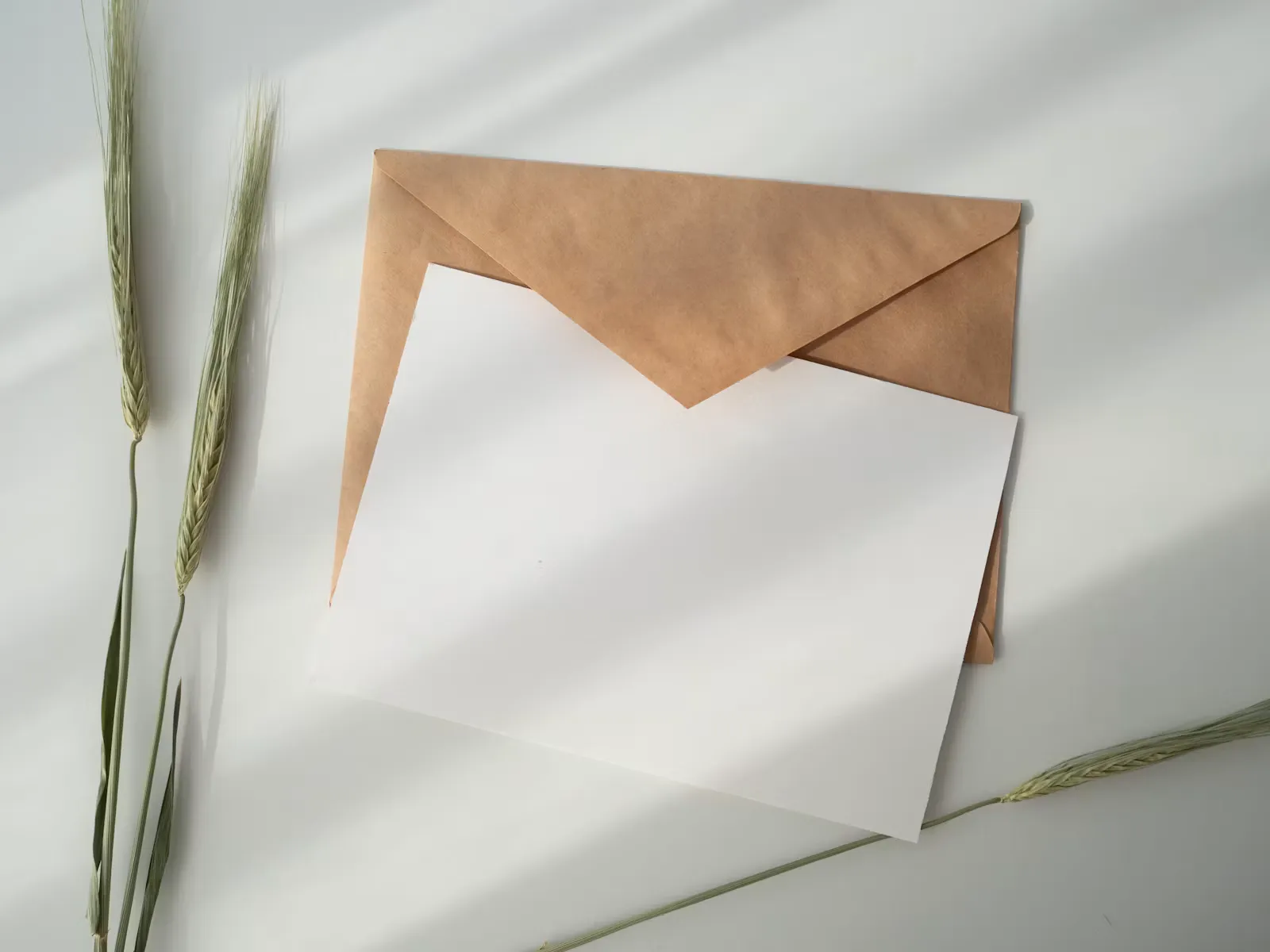 Weisses Blatt Papier liegt neben einem braunen Umschlag auf einem hellen Tisch, Sinnbild fuer das Aufgebot und die Einsatzvereinbarung im Zivildienst