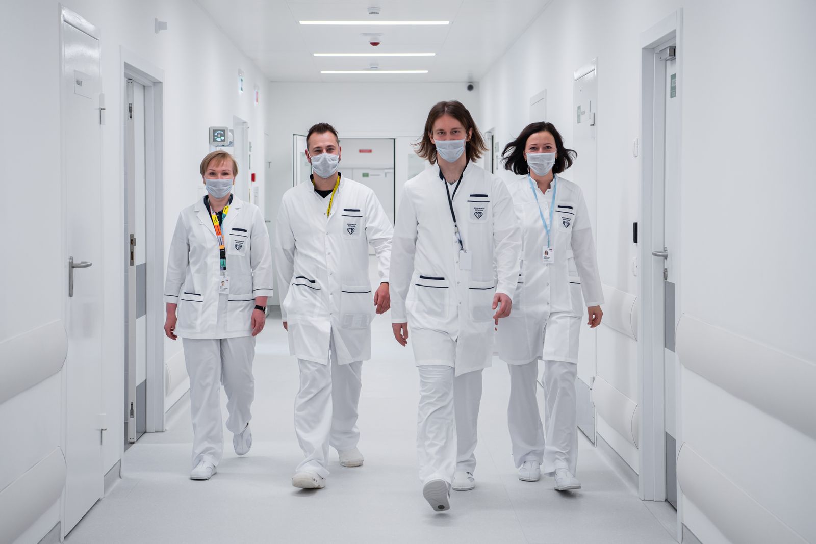 Doctors in white coats walking together down a hospital corridor on a ward round, illustrating an observership vs elective decision for medical students abroad