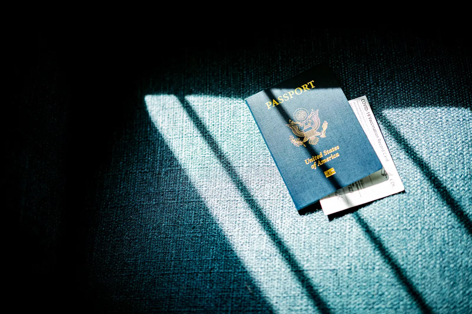 Blauer Reisepass mit Reiseunterlagen auf einem blauen Sofa als Symbolbild für die Dokumente vor dem Abflug nach Sansibar