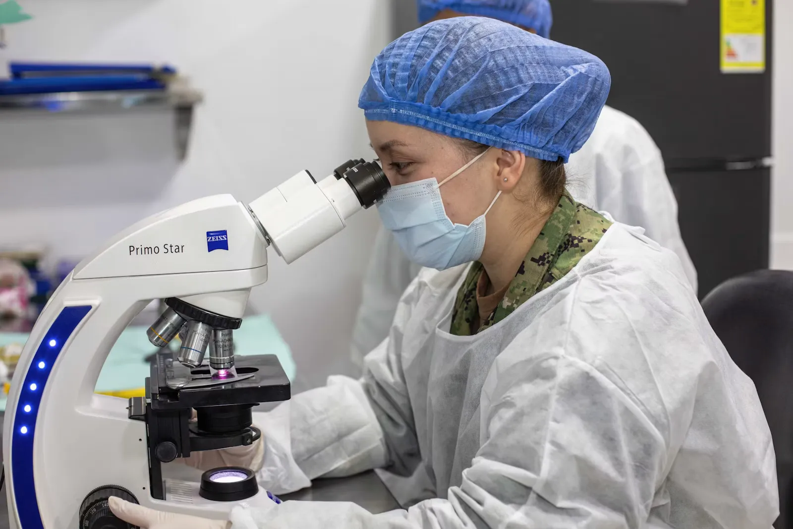 Wissenschaftlerin blickt im Labor durch ein Mikroskop bei der Diagnostik von Malaria während einer Tropenmedizin-Famulatur im Ausland