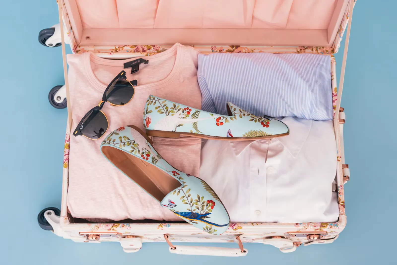 Offener Reisekoffer mit sorgfältig eingepackten Reiseutensilien für ein mehrwöchiges Auslandspraktikum