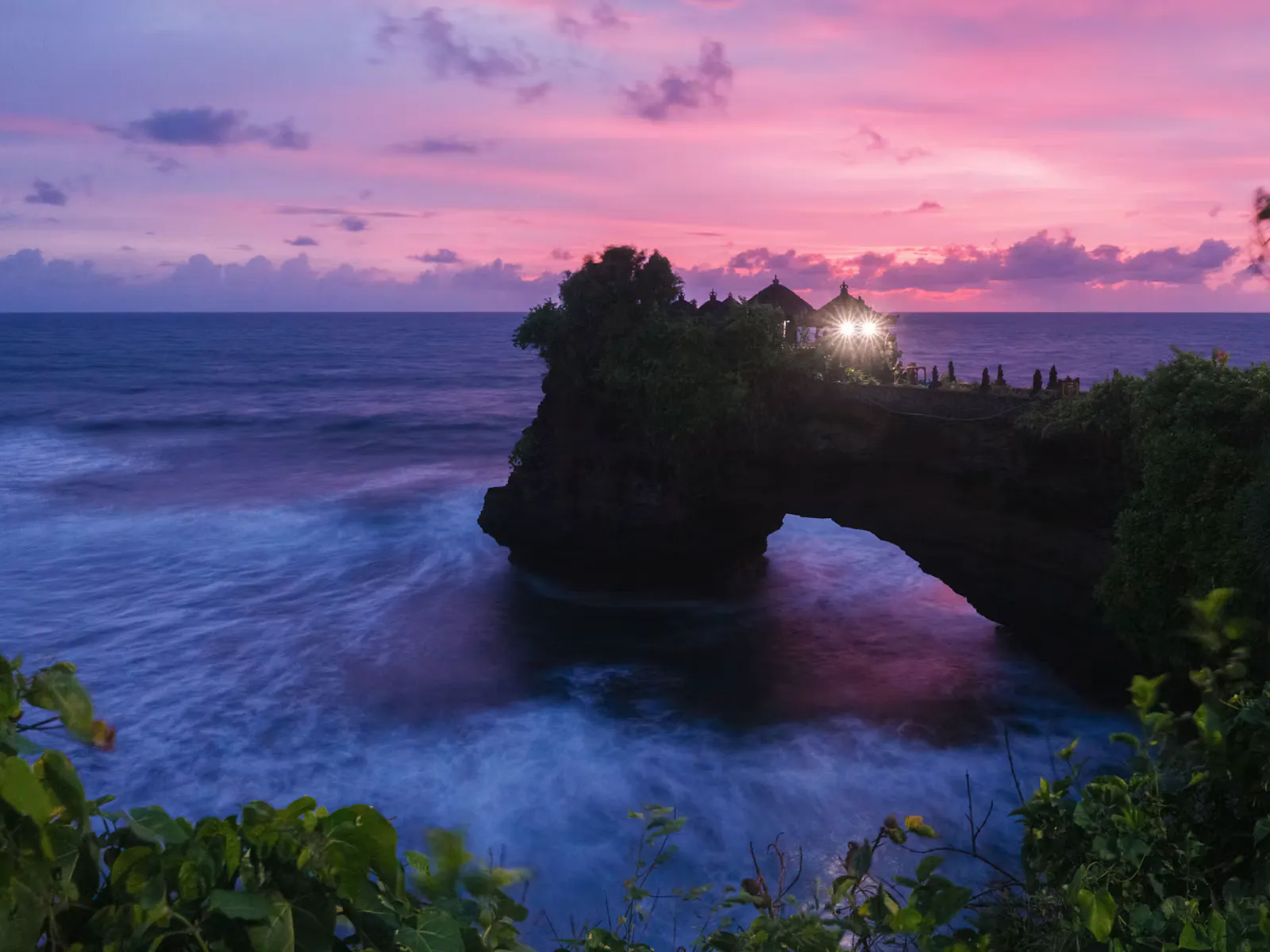 Temple on a rock arch above the sea on the west coast of Bali at dusk