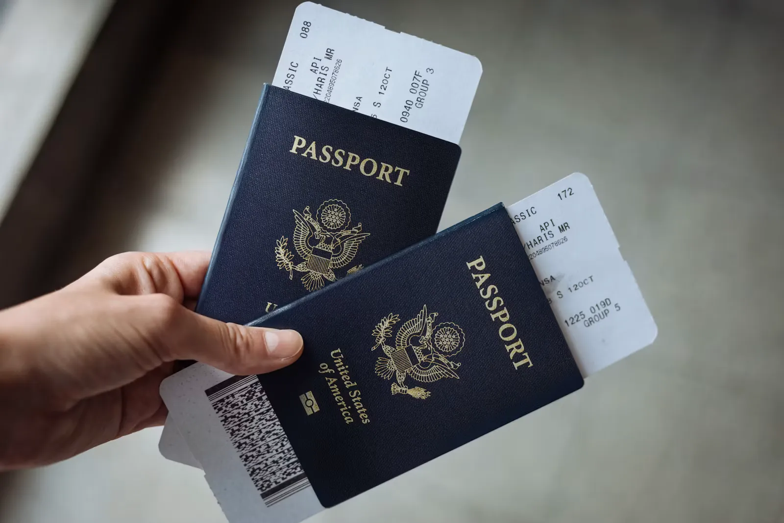 A hand holding two United States passports with airline boarding passes tucked inside, ready for a US medical elective trip