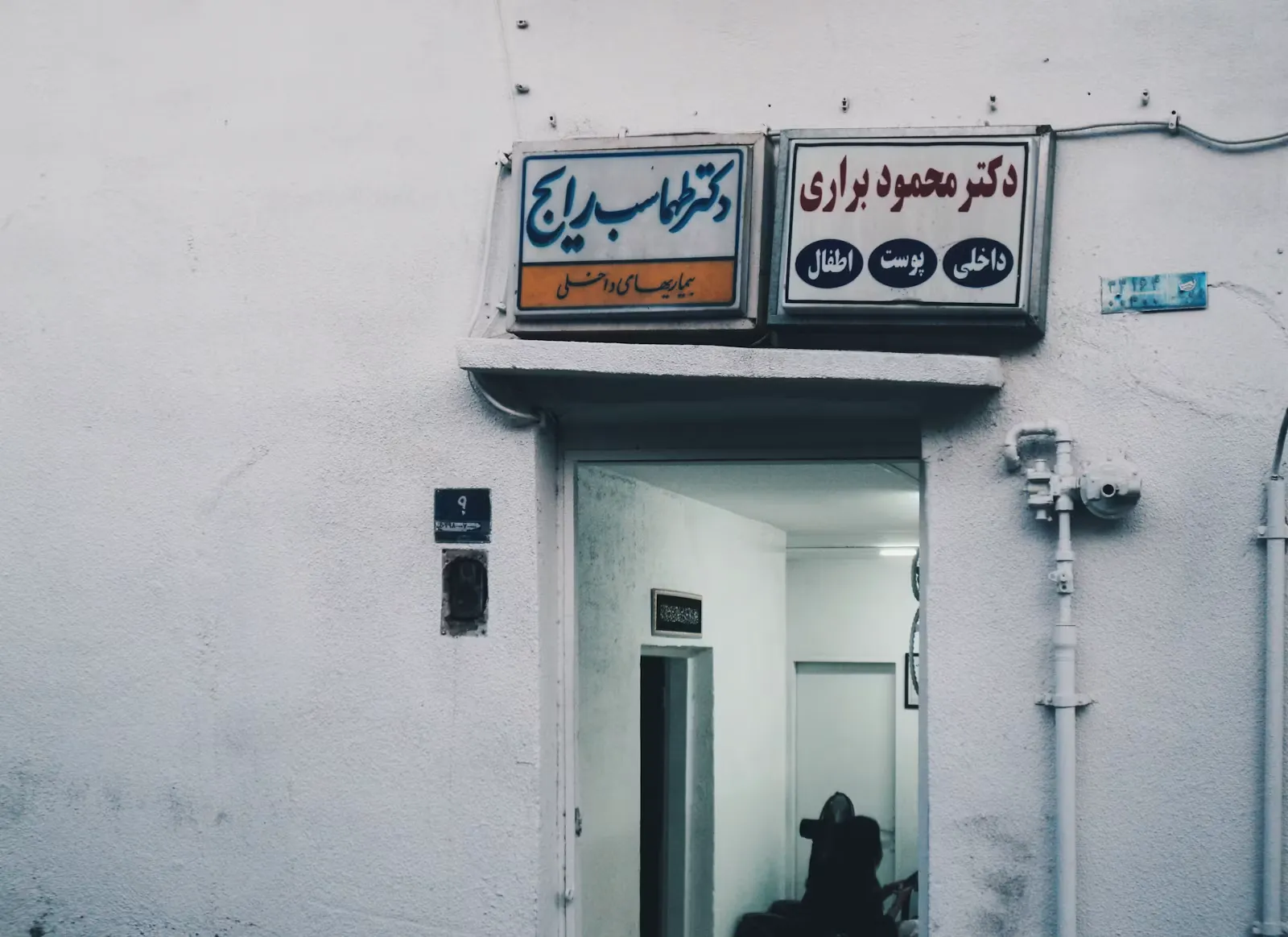 Two signs mounted above an open doorway