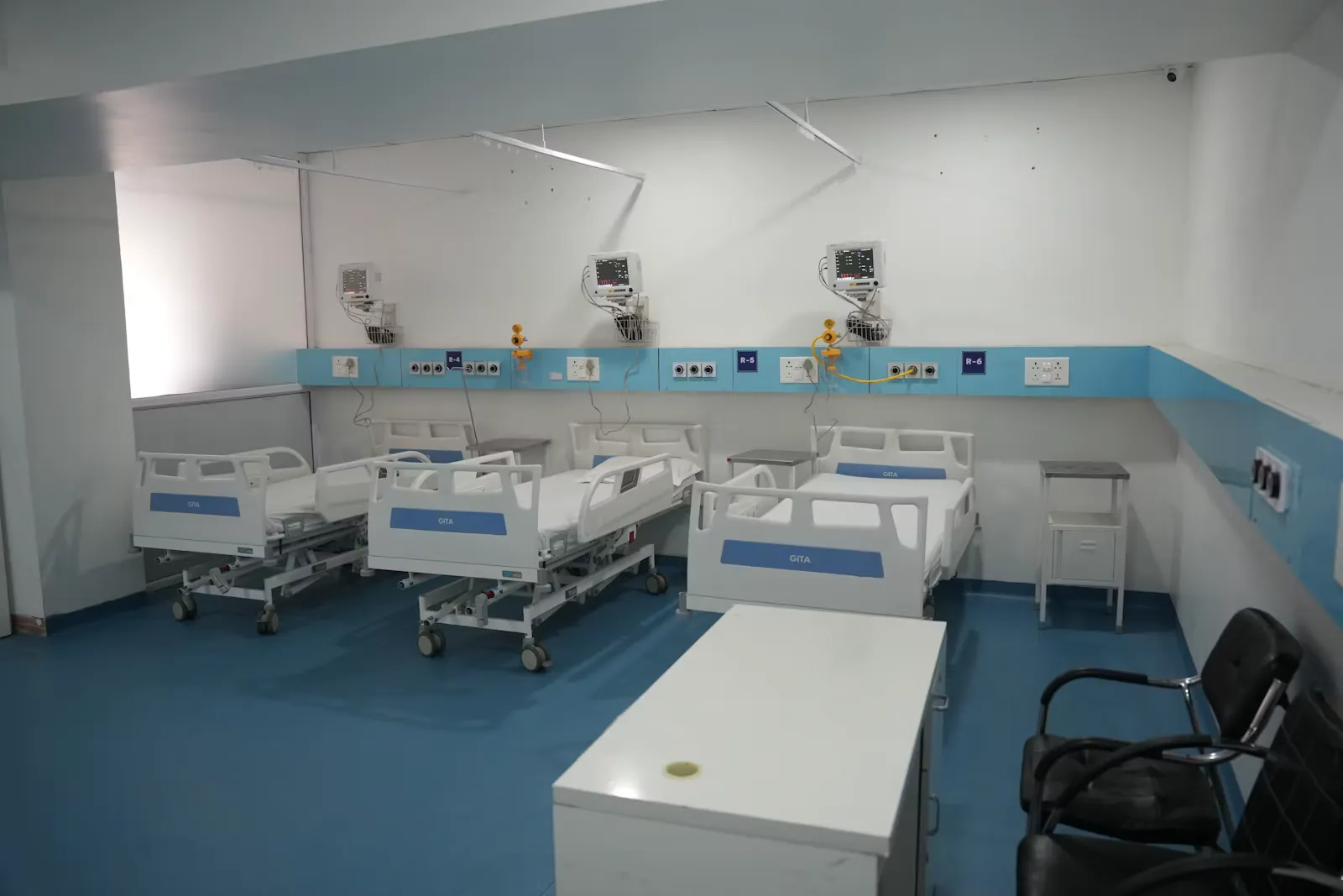 Spitalzimmer mit drei Betten und medizinischer Ausstattung