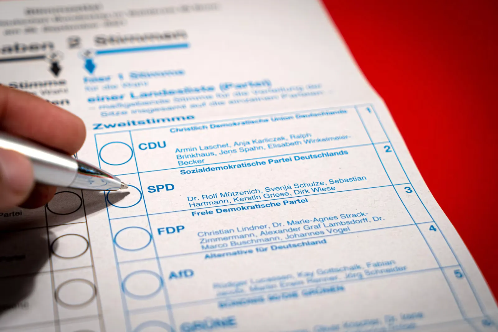 Person füllt mit einem Stift ein Formular aus