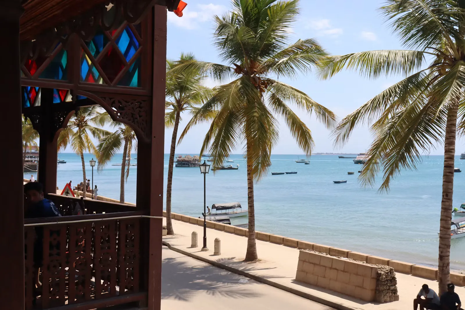 Blick von einer Terrasse auf Palmen und das türkisfarbene Meer in Stone Town, Sansibar, dem Standort für Famulatur und Pflegepraktikum in Tansania